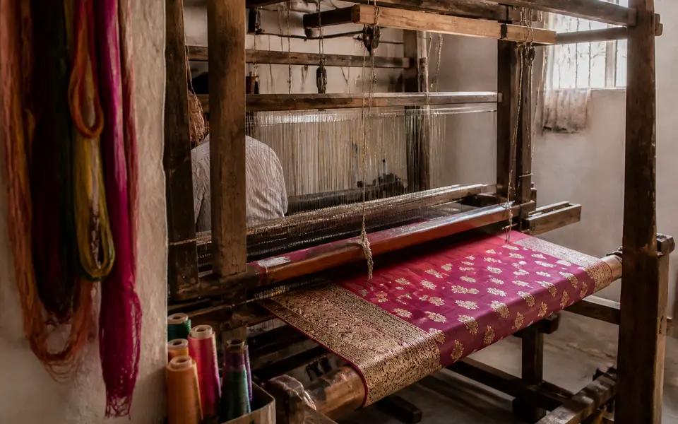 A Banarasi weaver working at a handloom with colourful silk threads in Varanasi.