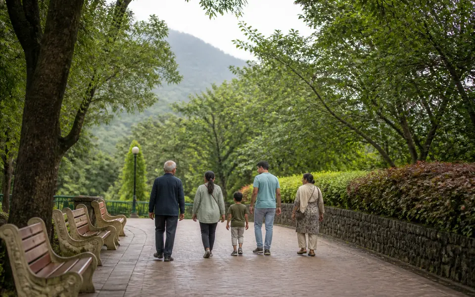 Family with children and older relatives walking along a tree-lined path in a hill-station park in Lonavala.