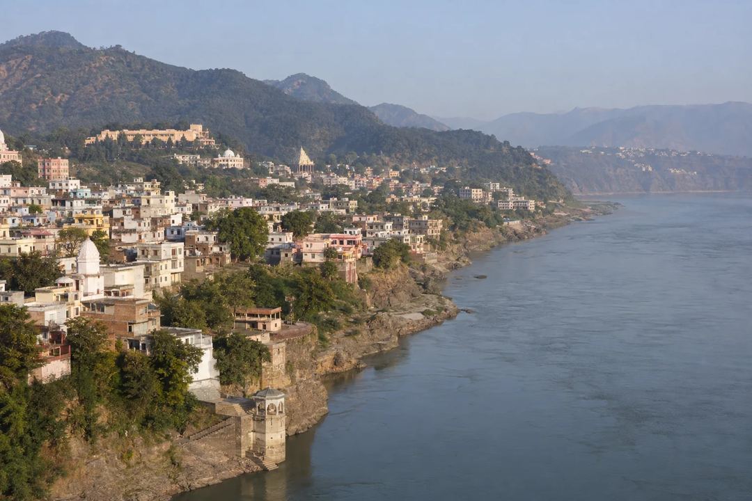 A panoramic view of Jammu city beside the Tawi River with wooded foothills beyond.