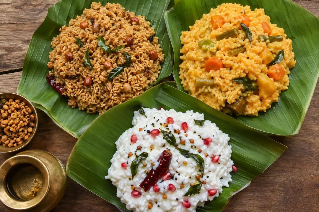 Puliyodarai sambar rice and curd rice served separately on banana leaves
