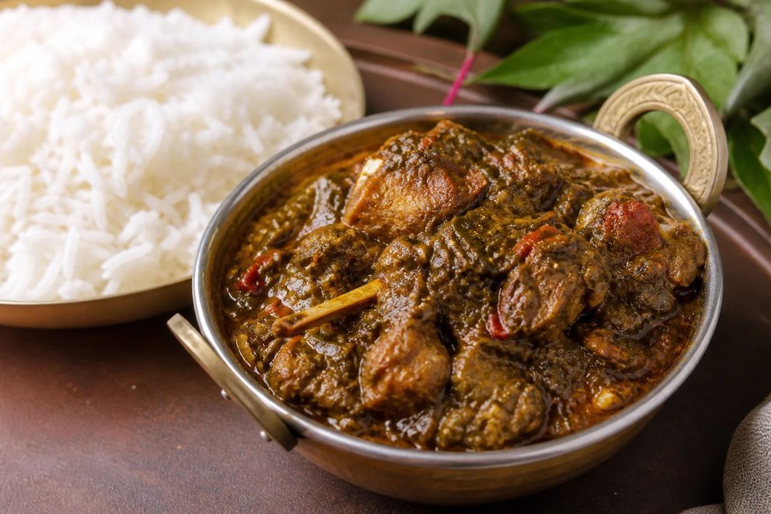 Gongura mutton in a deep sorrel leaf gravy beside plain steamed rice