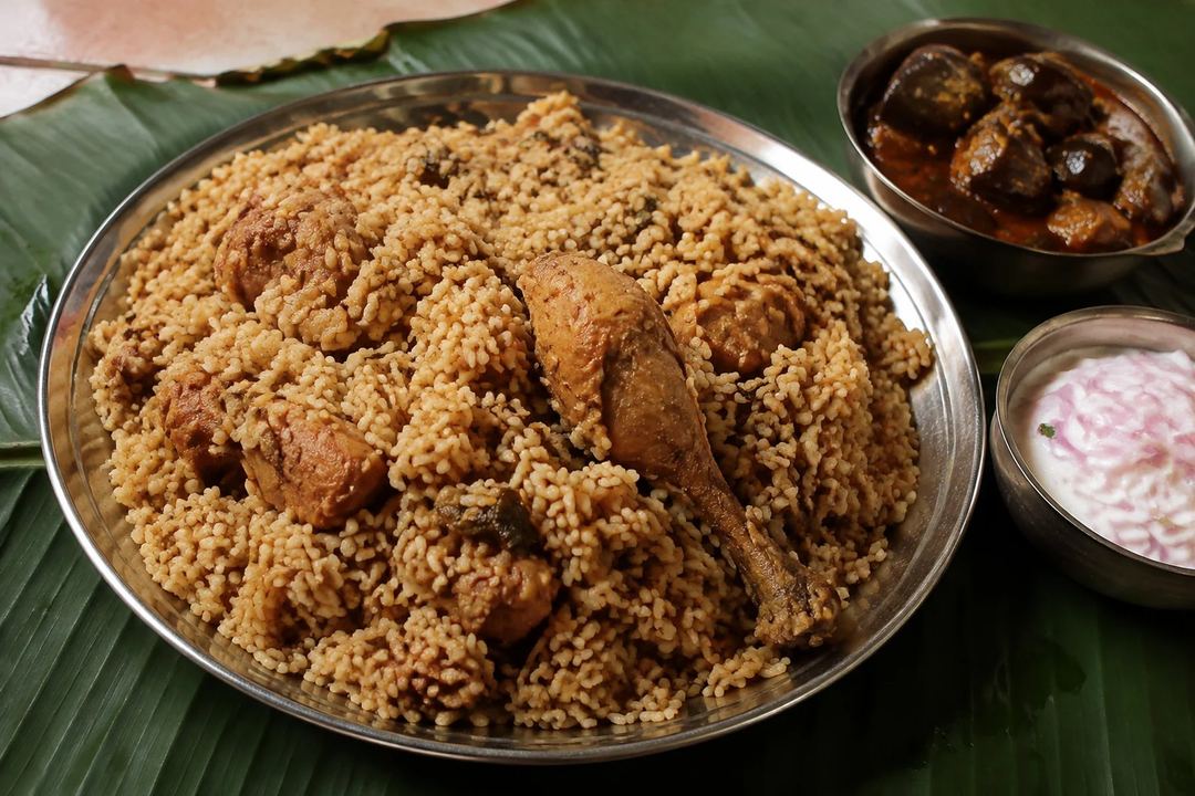 Ambur style chicken biryani with compact seeraga samba rice brinjal curry and onion raita