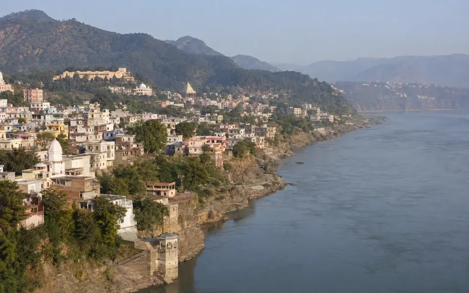 A panoramic view of Jammu city beside the Tawi River with wooded foothills beyond.
