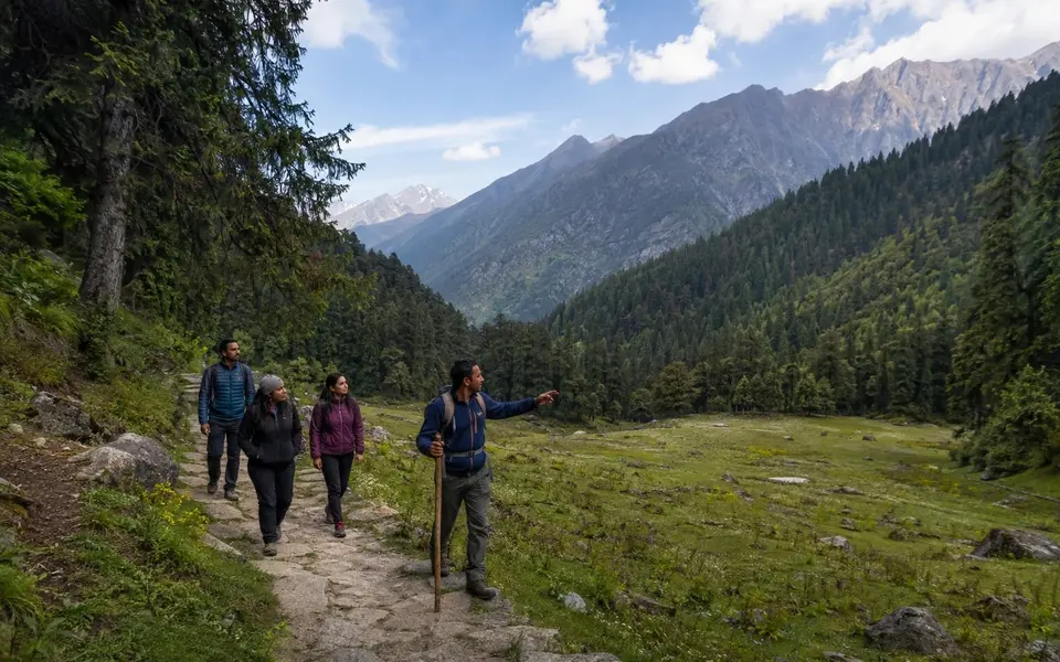 A local guide leads a small group along a designated trail in an Indian Himalayan landscape.