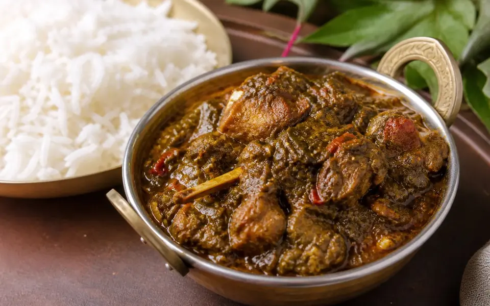 Gongura mutton in a deep sorrel leaf gravy beside plain steamed rice