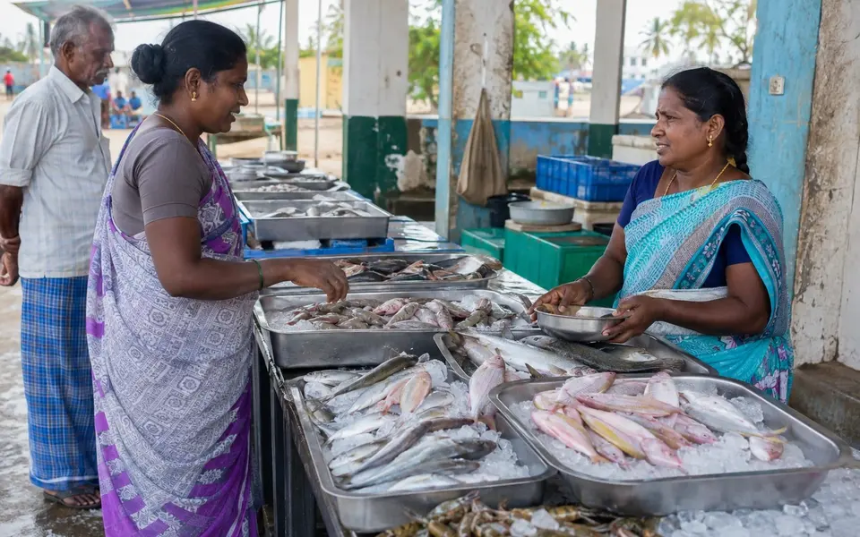 Shoppers and vendors at a clean coastal Tamil fish market with fresh fish displayed on ice