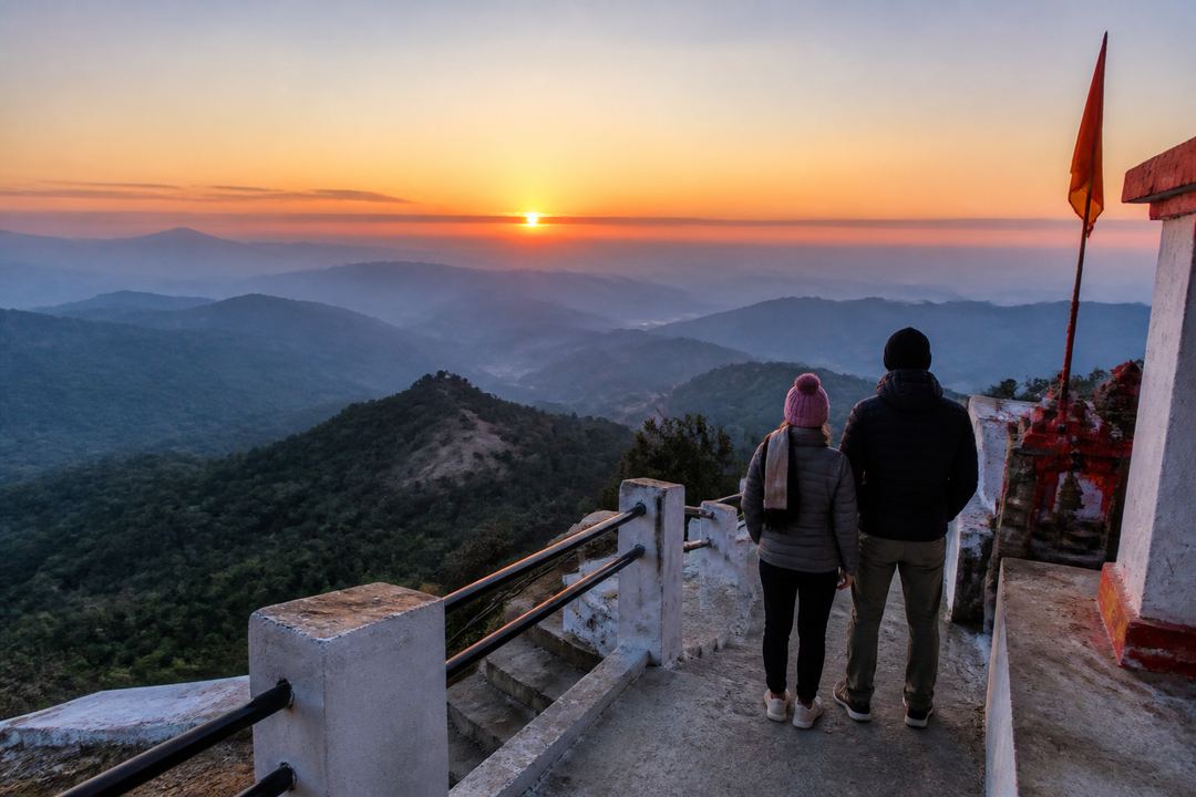 Sunrise view from a hilltop temple near Rishikesh with orange sky, layered foothills and a couple standing quietly at the viewpoint steps.