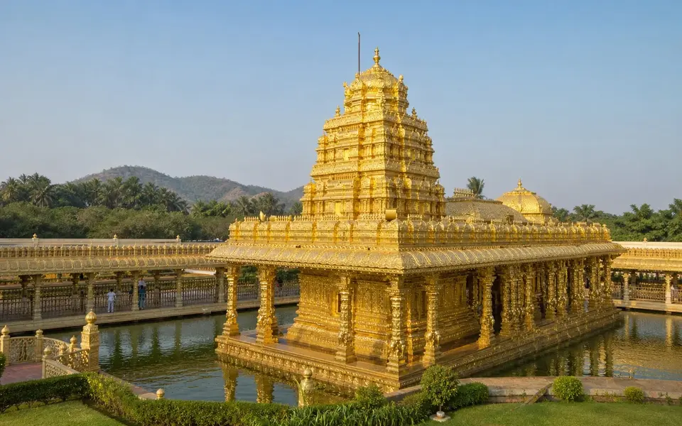 Reference-led landscape illustration of the gold-clad Sri Lakshmi Narayani shrine at Sripuram, surrounded by water, gardens and low green hills.