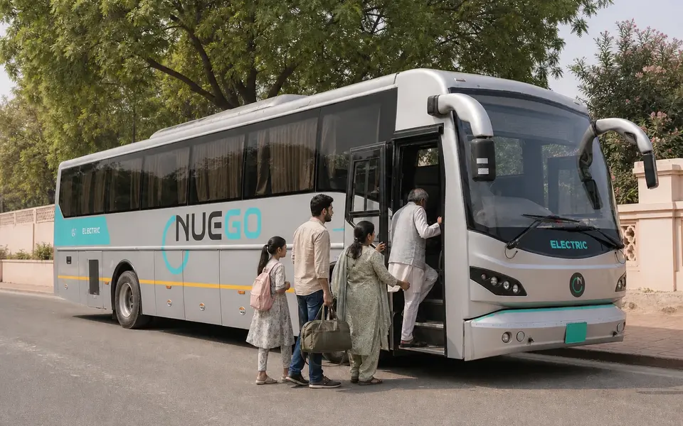 Family with luggage boarding a NueGo electric intercity coach for a Mathura–Vrindavan journey.