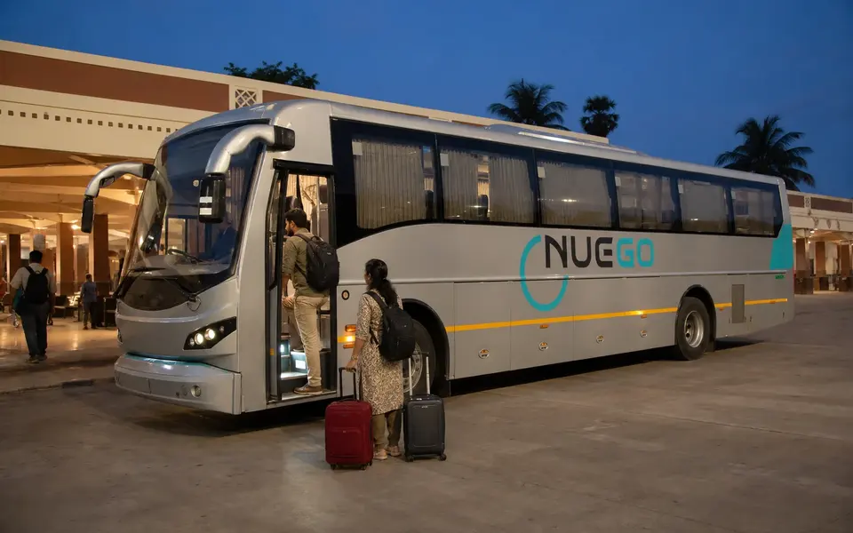 A couple boarding a clearly branded NueGo electric intercity coach for a Madurai journey.