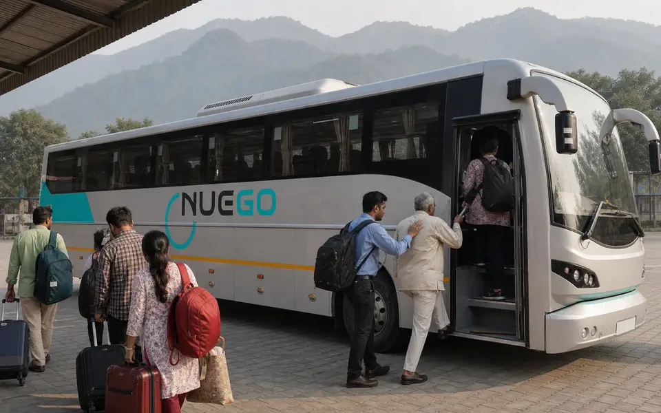 Travellers boarding a clearly branded NueGo electric intercity coach for a Haridwar journey at an Indian bus terminal.
