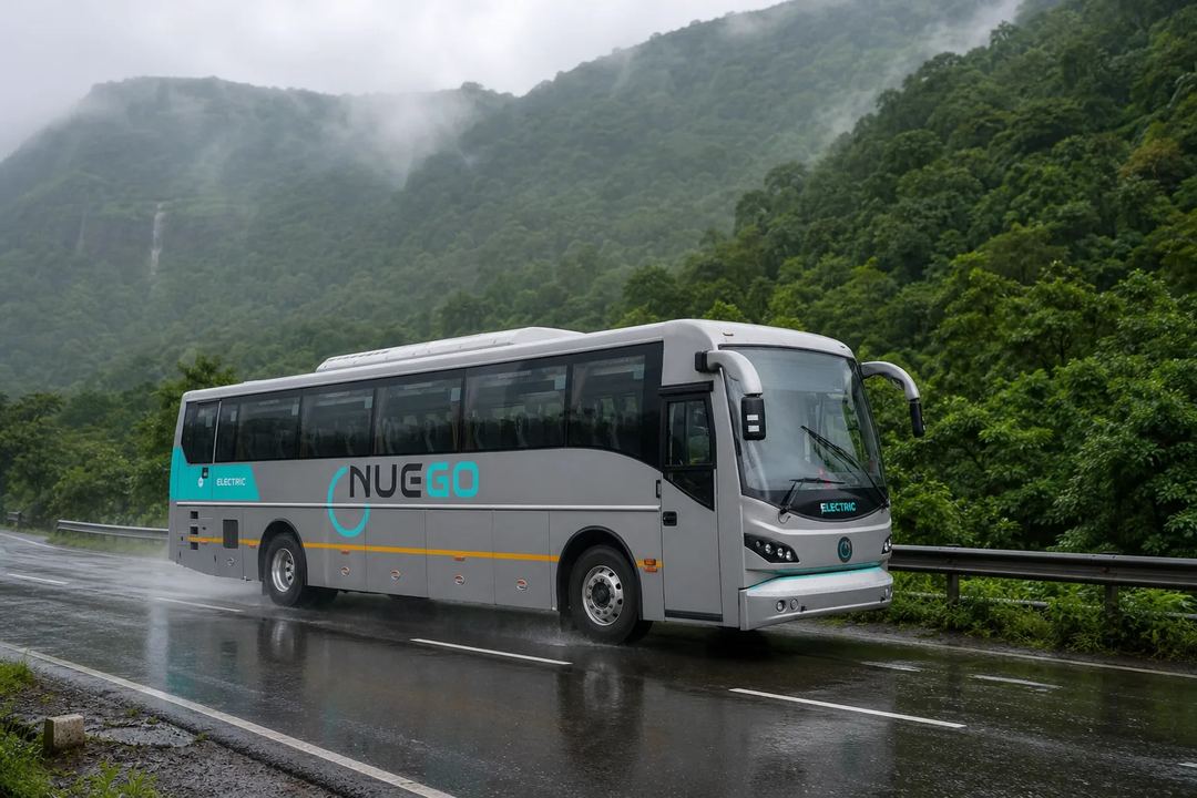 NueGo electric intercity coach travelling on a wet Indian highway during monsoon rain.