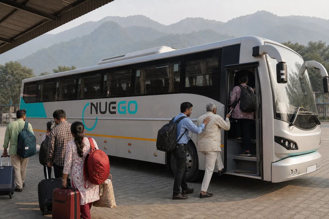 Travellers boarding a clearly branded NueGo electric intercity coach for a Haridwar journey at an Indian bus terminal.
