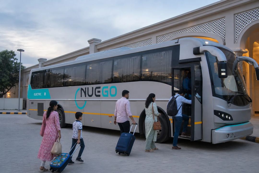 NueGo-branded electric intercity coach at a clearly marked boarding point, with no unrelated route name visible.