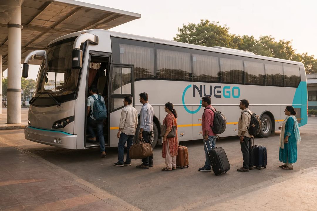 Passengers boarding a clearly branded NueGo electric intercity coach for a Varanasi journey at an Indian bus terminal.