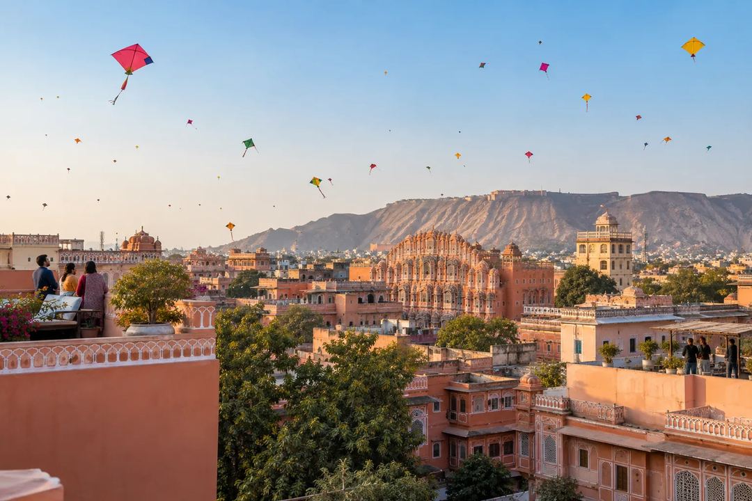 Illustration of colourful kites above Jaipur’s rooftops with hills in the distance.