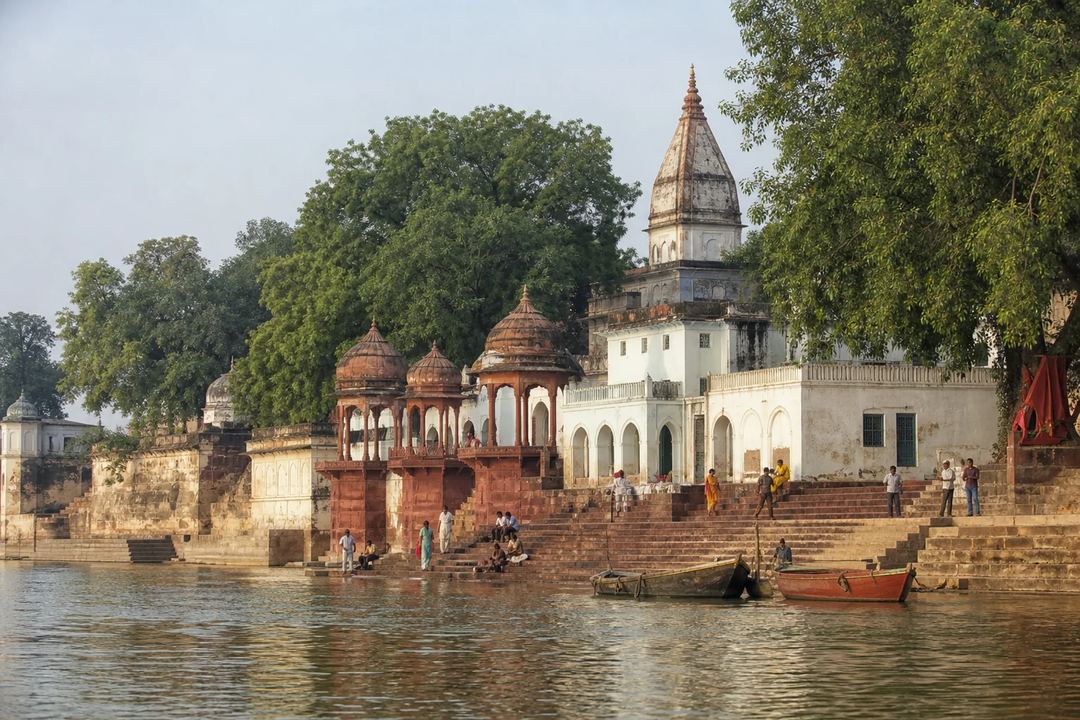 Illustrative view of Bithoor's Ganga riverfront ghats with temple pavilions and boats.